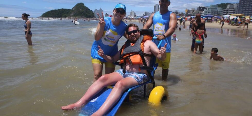 Pessoas com mobilidade reduzida podem tomar banho de mar em cadeiras adaptadas nas praias do litoral paranaense